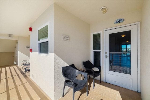 property entrance featuring visible vents and stucco siding