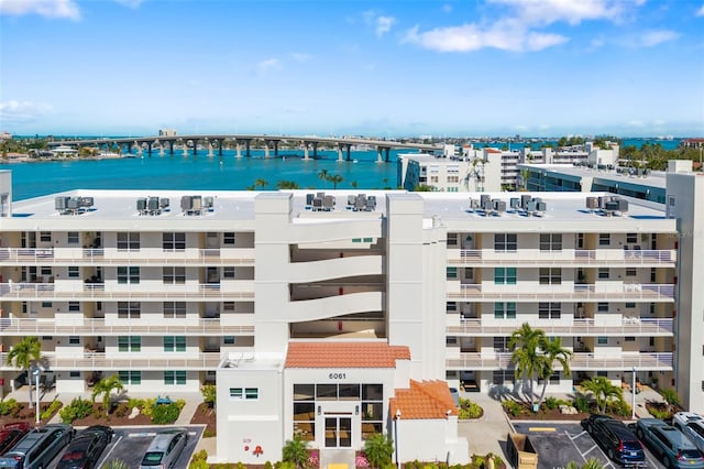 view of property with uncovered parking and a water view