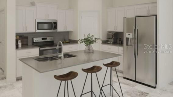 kitchen featuring white cabinetry, a kitchen breakfast bar, and stainless steel appliances