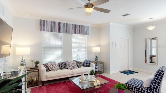 living area with ceiling fan, visible vents, baseboards, and ornamental molding