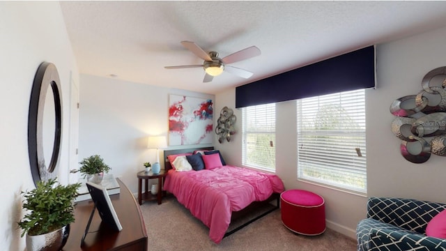 bedroom with a textured ceiling, baseboards, a ceiling fan, and carpet floors