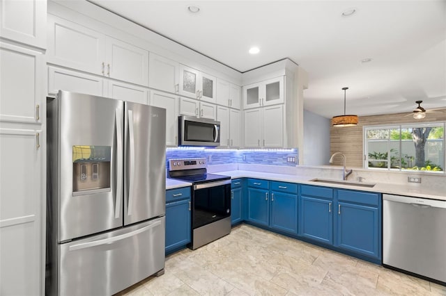 kitchen with blue cabinets, a sink, white cabinetry, stainless steel appliances, and light countertops