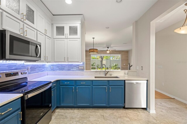 kitchen with a sink, stainless steel appliances, blue cabinets, and light countertops