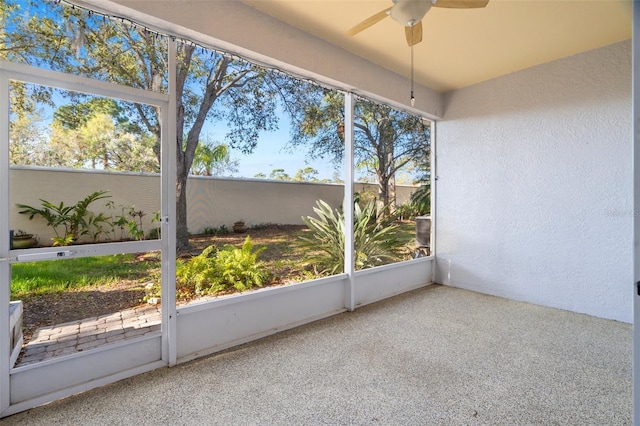 unfurnished sunroom featuring a ceiling fan