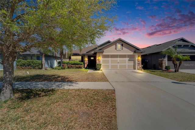 view of front of house featuring stucco siding, driveway, stone siding, a yard, and an attached garage