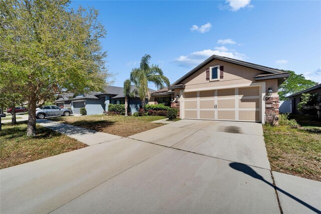 single story home featuring stucco siding, concrete driveway, and an attached garage