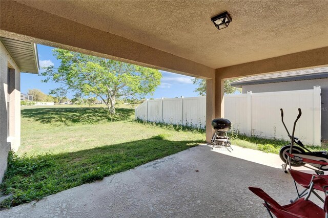 view of patio featuring a grill and fence