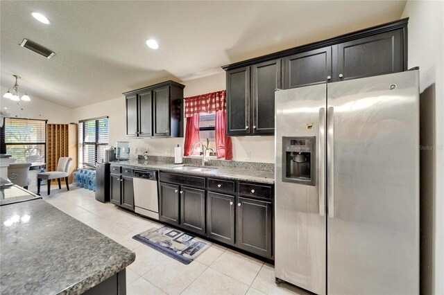 kitchen with light tile patterned floors, visible vents, lofted ceiling, a sink, and appliances with stainless steel finishes