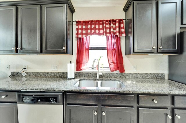 kitchen with a sink, light stone countertops, and dishwasher