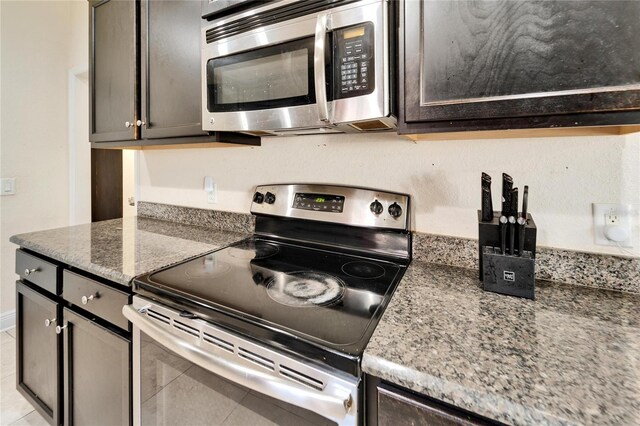 kitchen with stainless steel appliances and dark stone counters