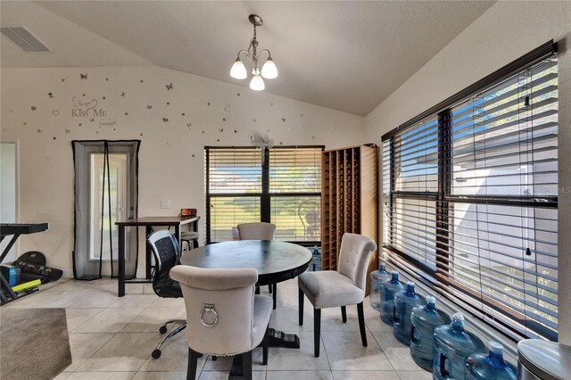 dining area with lofted ceiling, light tile patterned flooring, visible vents, and a chandelier