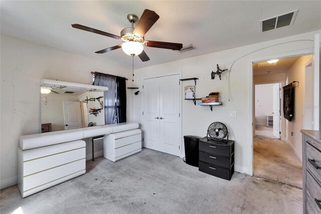 carpeted bedroom with visible vents, baseboards, a closet, and a ceiling fan