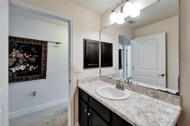 bathroom featuring vanity, baseboards, and visible vents