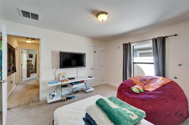 carpeted bedroom featuring visible vents, baseboards, and a textured ceiling