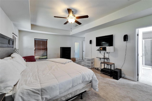 bedroom with visible vents, ensuite bathroom, a ceiling fan, a tray ceiling, and carpet