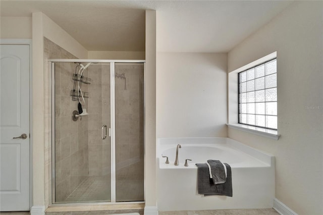 full bathroom with a shower stall and a bath