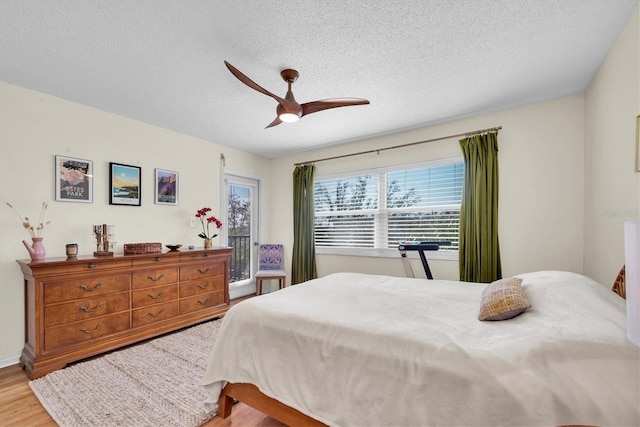 bedroom with ceiling fan, a textured ceiling, and wood finished floors