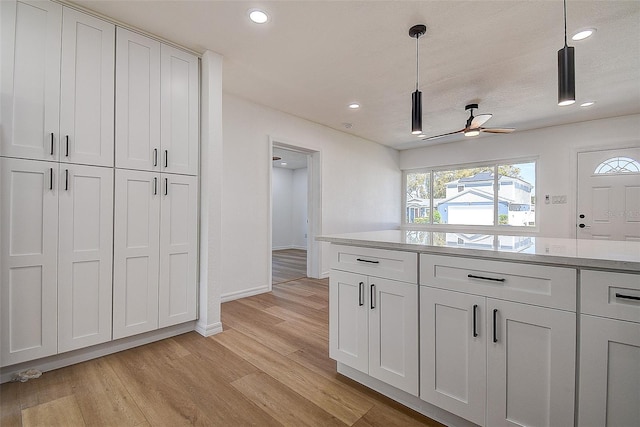 kitchen with white cabinets, recessed lighting, a healthy amount of sunlight, and light wood finished floors