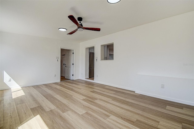 empty room featuring baseboards, light wood-style floors, and a ceiling fan