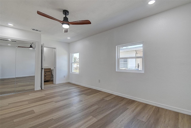 unfurnished bedroom with baseboards, visible vents, recessed lighting, a closet, and light wood-type flooring