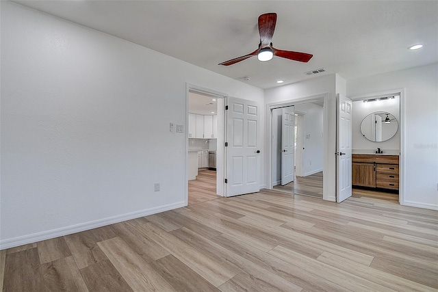 unfurnished bedroom featuring visible vents, ensuite bath, light wood-type flooring, and baseboards