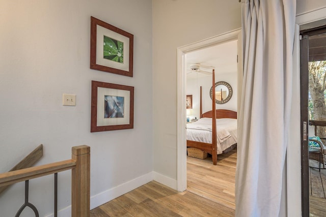 corridor with baseboards and wood finished floors