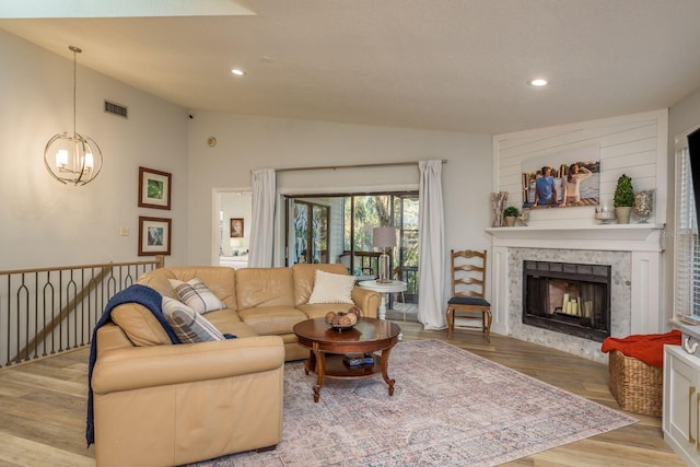 living area featuring wood finished floors, visible vents, lofted ceiling, recessed lighting, and a notable chandelier