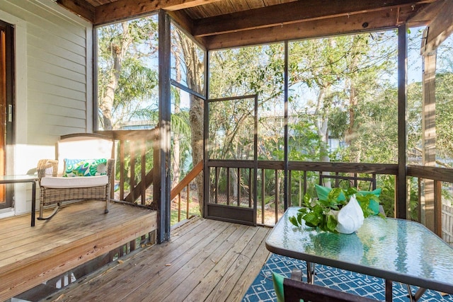 sunroom / solarium featuring beam ceiling