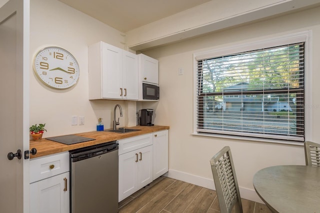 kitchen with a sink, butcher block counters, black microwave, dishwasher, and wood tiled floor