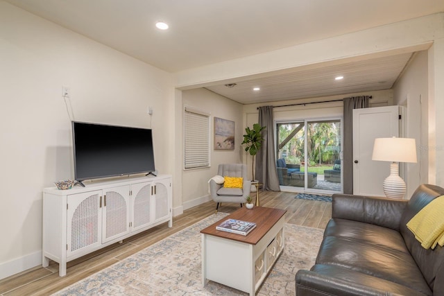 living room with recessed lighting, light wood-style floors, and baseboards