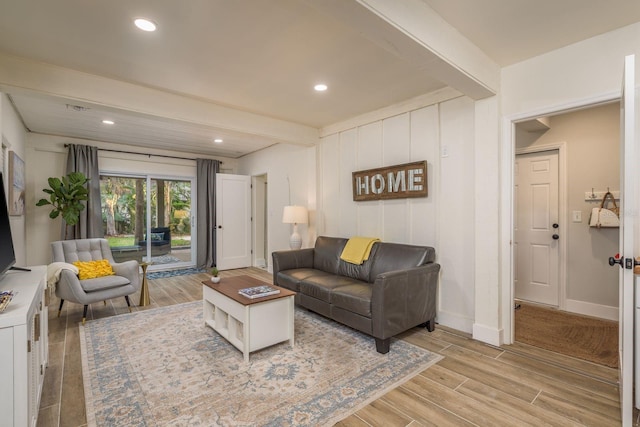 living room with recessed lighting, baseboards, beam ceiling, and light wood finished floors