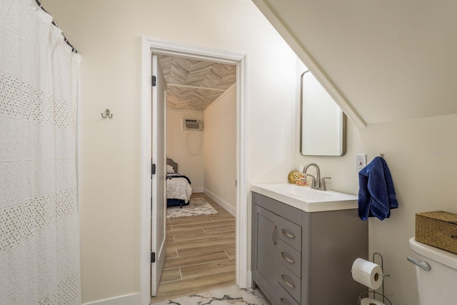 full bathroom featuring baseboards, wood tiled floor, toilet, vanity, and a wall mounted AC