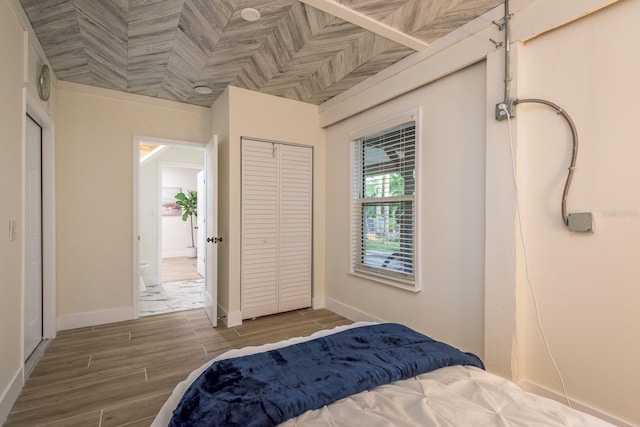 bedroom featuring a closet, baseboards, and wood finished floors