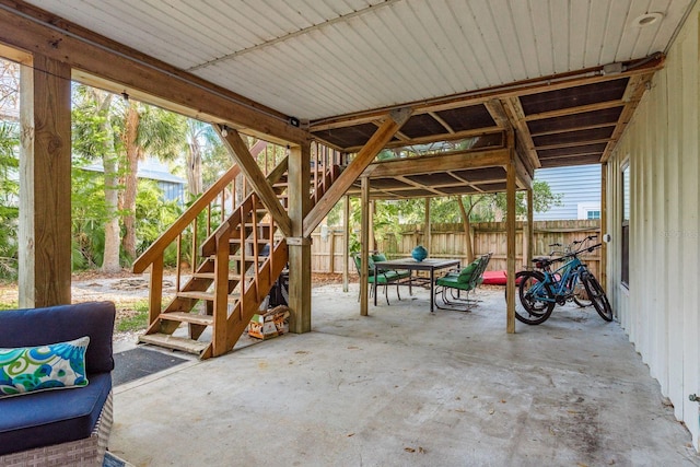 view of patio / terrace with stairway, outdoor dining space, and fence