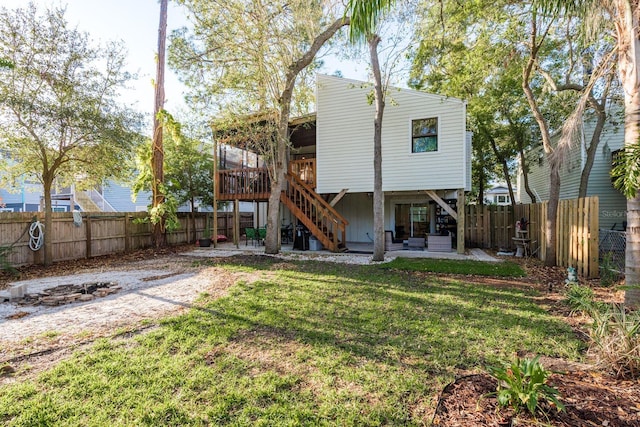 back of property with a fenced backyard, stairs, a deck, a patio area, and a lawn