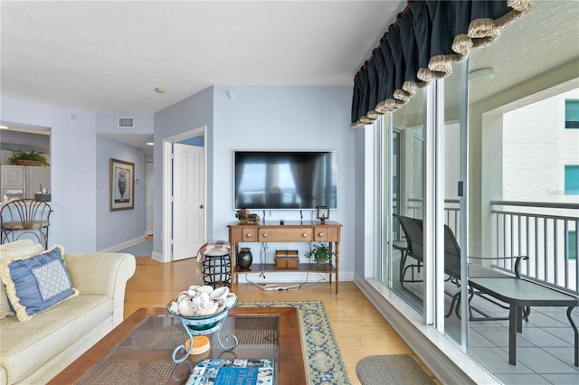 living area with visible vents, wood finished floors, and baseboards