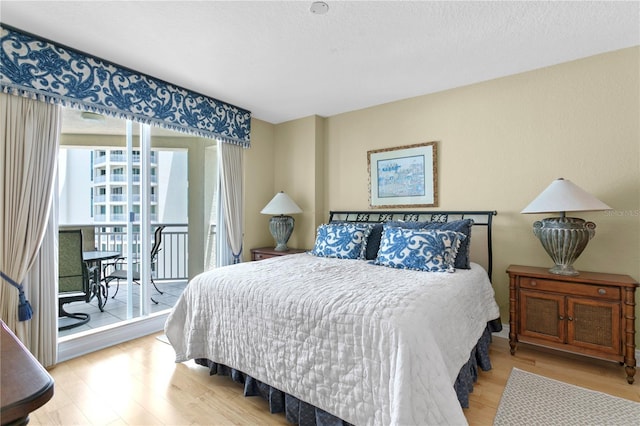 bedroom with wood finished floors and access to outside