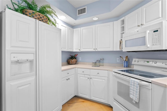 kitchen with visible vents, white appliances, light countertops, and white cabinetry