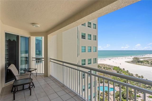 balcony featuring a beach view and a water view