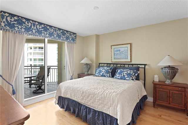 bedroom featuring access to exterior and wood finished floors
