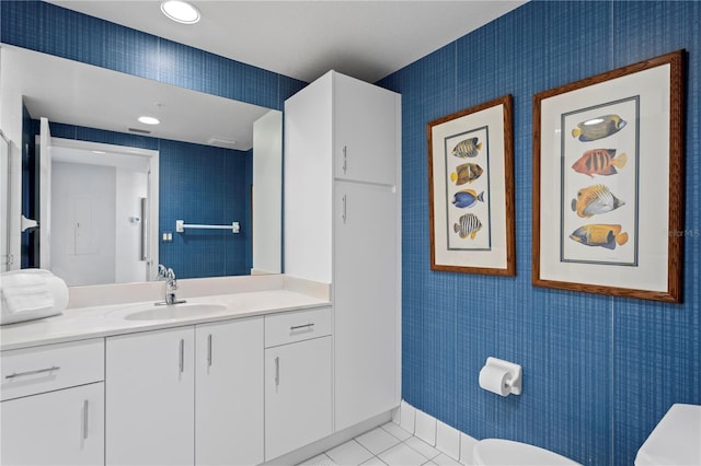 bathroom with tile patterned floors, toilet, vanity, and wallpapered walls