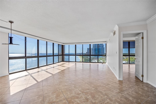 empty room featuring baseboards, a city view, ornamental molding, and floor to ceiling windows