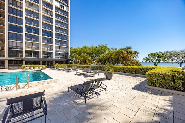 community pool featuring a patio and a water view