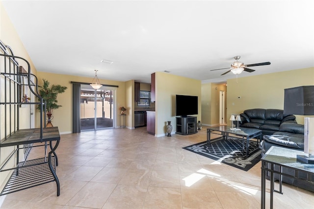 living area featuring light tile patterned floors, baseboards, and ceiling fan