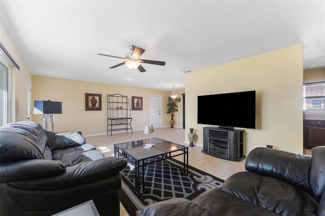 living area featuring light tile patterned flooring, visible vents, baseboards, and ceiling fan