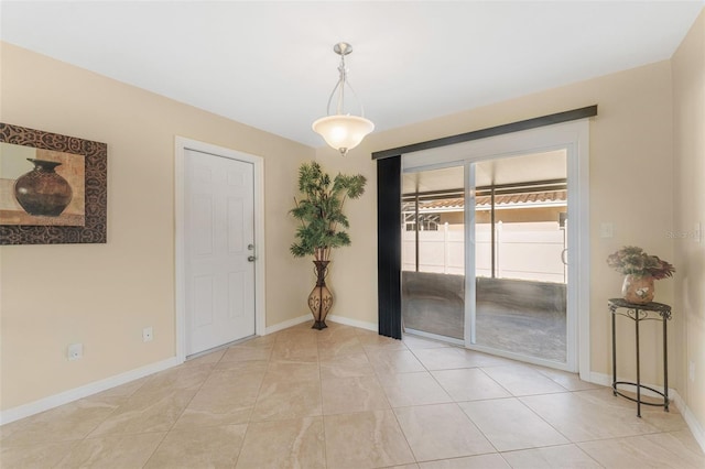 empty room featuring light tile patterned floors and baseboards