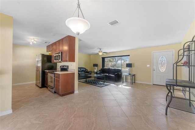 kitchen with visible vents, brown cabinets, a ceiling fan, stainless steel appliances, and light countertops