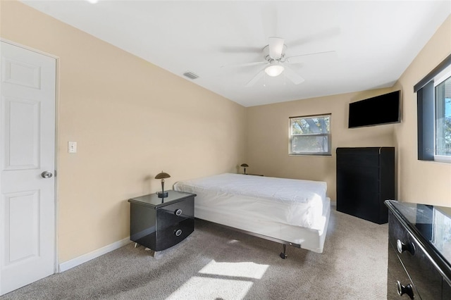 carpeted bedroom with visible vents, baseboards, and a ceiling fan