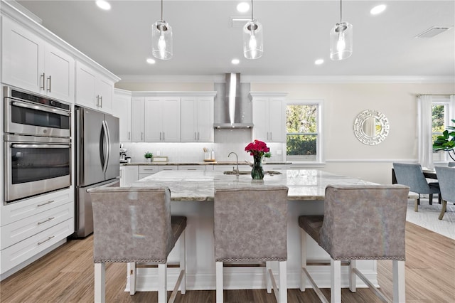 kitchen featuring decorative backsplash, wall chimney range hood, ornamental molding, and stainless steel appliances