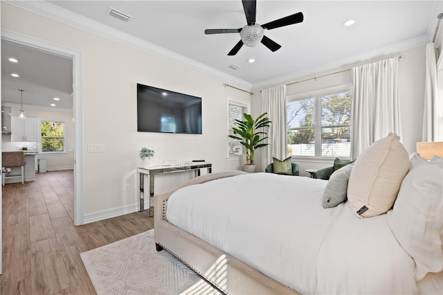 bedroom featuring light wood finished floors, visible vents, and ornamental molding